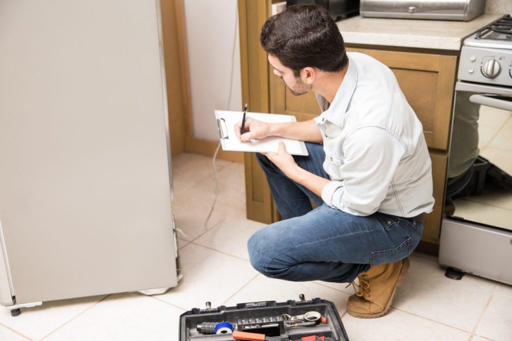 Un technicien examine un réfrigérateur qui fonctionne sans arrêt, avec les parois latérales chaudes.